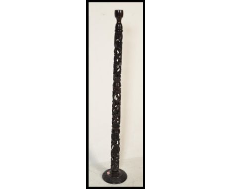 A 20th Century African tribal carved hard wood standard lamp constructed from pierced decoration totems of carved figures wit