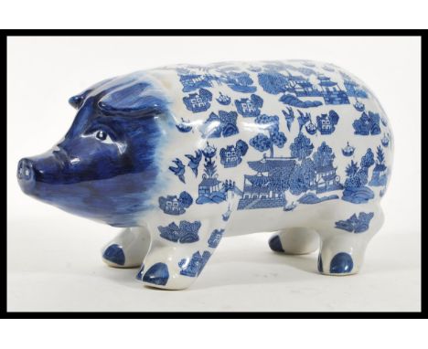 A vintage 20th Century large ceramic money bank box in the form of a pig having blue and white decoration in the Chinese tast