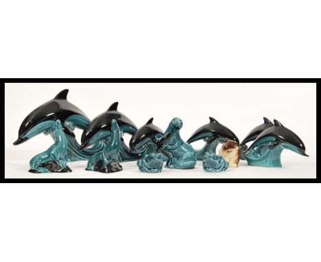 A collection of Poole pottery ceramic figurines having a blue glaze in the form of animals to include six graduating dolphins