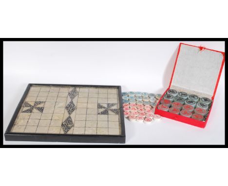 A 20th century Chinese checkers board game having stone counters gaming pieces having calligraphy lettering contained within 