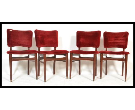 A set of four vintage retro 20th Century dining chairs raised on tapering legs with red velour seats and backs.