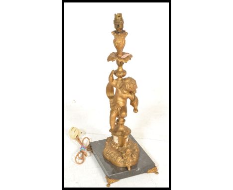 A 20th Century French cast metal gilt table lamp inthe form of a cherub on a turned column raised on a naturalistic base with