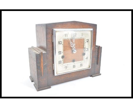 A 20th century Art Deco mantel clock having squarer silver dial chrome glaze door in a mahogany case together with key and pe