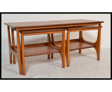 A vintage retro 20th Century teak wood occasional coffee nest of tables consisting of a taller coffee table with two smaller 