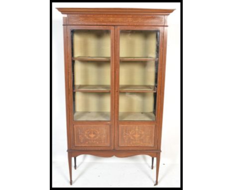 An early 20th Century Edwardian mahogany china display cabinet vitrine having box wood inlay raised on tapering legs with arr