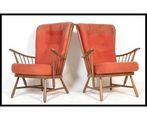 A pair of Ercol beech spindle back fireside armchair,&nbsp; with upholstered cushions, raised on turned legs united by an H f