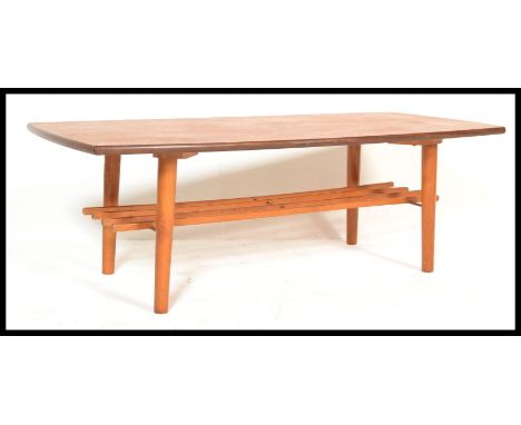 A retro vintage 20th century teak wood coffee table raised on tapering supports having rail magazine ruck underneath. Measure