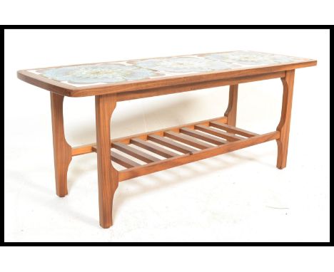 A vintage retro 20th Century teak wood tile top coffee table having a sectional vibrant blue retro print flower tile top on s
