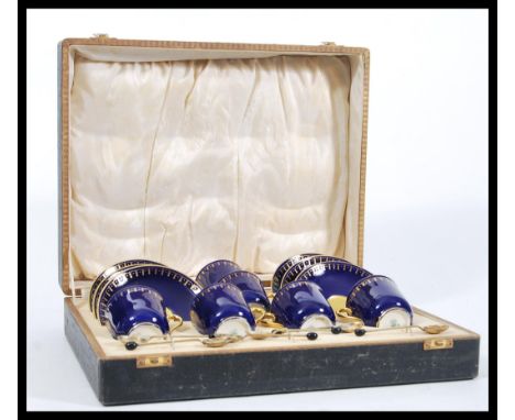 A set of 20th Century Coalport coffee cups and saucers having gilt interiors and cobalt blue exteriors along with a selection