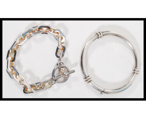 A silver hallmarked chain link bracelet having a toggle clasp together with a stamped 925 silver bangle bracelet having a hin