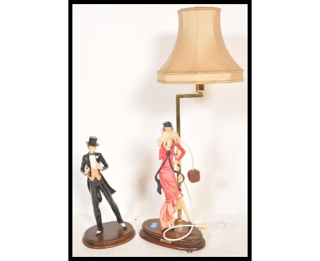 A 20th Century Santini Capodimonte style table lamp having a wooden base with a cast resign flapper girl figure above, culmin
