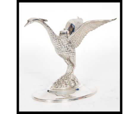 A 20th Century cast silver white metal brandy glass warmer in the form of a crane with extended wings raised on an oval base,