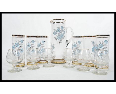A retro 20th Century glass lemonade set consisting of a tall jug with six matching hi-ball glasses all decorated with floral 