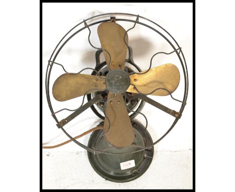 A vintage early 20th Century industrial cast metal desk top oscillating fan by TBH, raised on a pedestal base. Measures 35 cm