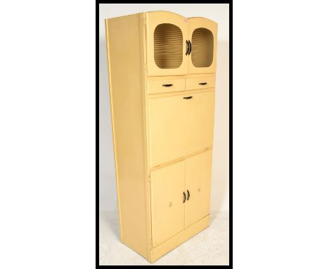 A vintage mid 20th Century upright kitchen cupboard, having an arrangement of drawers and cupboards, the central cupboard bei
