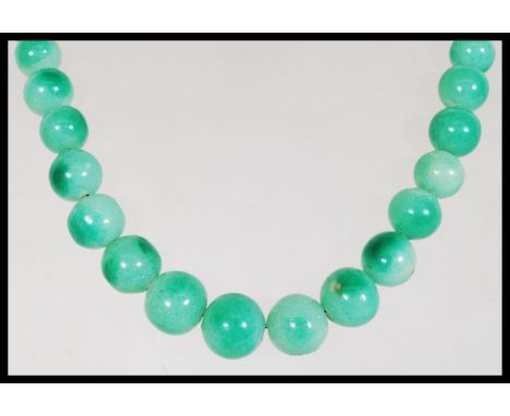 A vintage Chinese believed green jade or Peking glass prayer bead necklace having a graduating set of round beads and barrel 