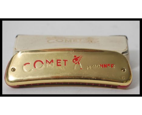 A rare vintage 20th Century M Hohner Comet space age harmonica having a gilt brass body with red bakelite bands and red lette