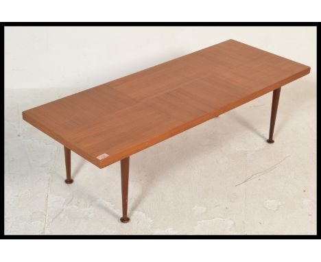 A vintage mid 20th Century teak wood coffee table, the rectangular top raised on shaped tapering supports. Measures 35 cm hig