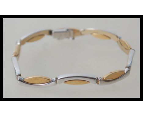 A contemporary hallmarked 9ct gold white and yellow gold bracelet chain having a lozenge and bone link with hidden clasp. Wei