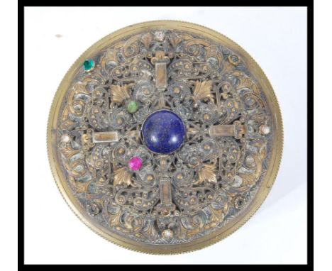 A 19th Century circular brass trinket / powder box pot having pierced raised decoration decorated with semi precious stones.