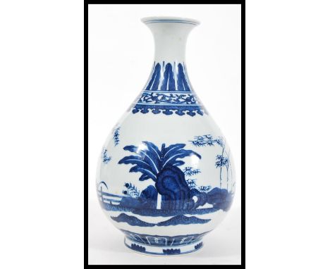 A 20th Century Chinese blue and white porcelain vase of baluster form having hand painted scenes depicting garden fence with 