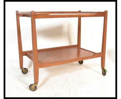 A vintage retro 20th Century teak wood two tier Danish trolley raised on angular supports terminating on original castors. Me