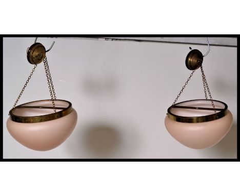 A pair of vintage retro 20th Century ceiling lights having a brass ceiling bracket with a dusty pink frosted glass shade, sus