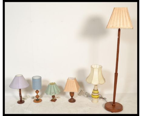 A collection of retro 20th Century teak wood desk lamps of differing designs together with a teak wood standard lamp. Measure