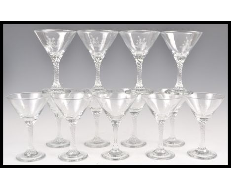 A collection of thirteen vintage retro Babycham glasses having grey etched logos to the bowls and with twisted stems.