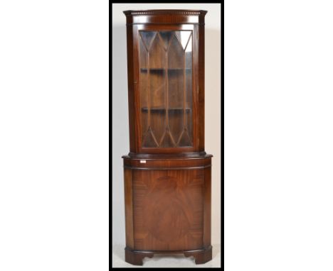 A 1930's walnut demi-lune china display cabinet having stained glass upper sections with lozenge shaped design, shelves insid