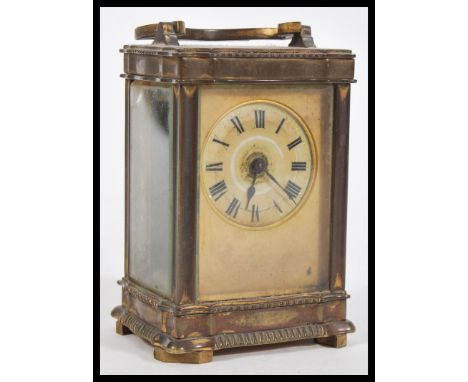 A 19th Century French brass carriage clock having a Roman numeral chapter ring with swing handle atop and bevelled glass pane
