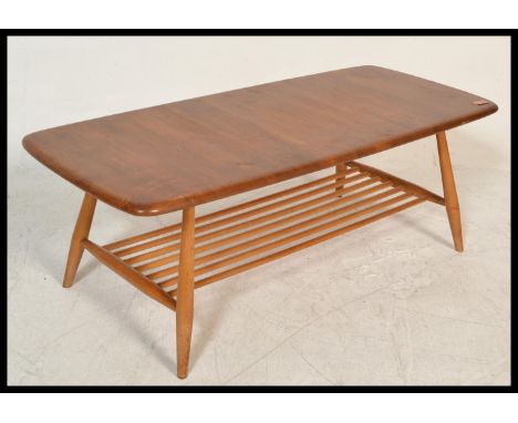 A retro 20th Century Ercol Golden Dawn beech and elm coffee table raised on tapering supports united with slatted undertier, 