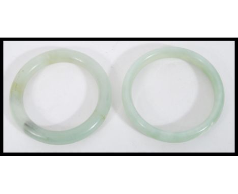 A pair of Chinese jade bangle bracelets of circular form. Measures 8.5 cm diameter.