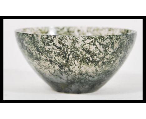 A Chinese jade tea bowl of small proportions having a clear jade body with green and white mottled decoration . Signed to bas