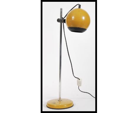 A vintage retro 20th Century Eyeball desk lamp raised on circular base with adjustable tubular column and mustard yellow atom
