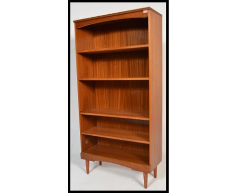 A vintage retro 20th Century teak wood tall bookcase cabinet raised on tapering legs with fitted shelves.