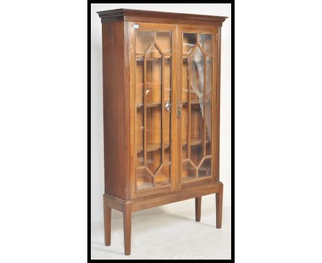 An early 20th Century mahogany Chippendale revival bookcase on stand having twin astragal glazed doors with shelved interior.