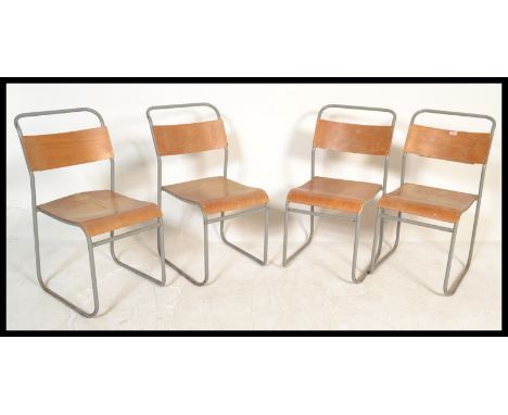 A set of four vintage / retro stacking chapel chairs, the chairs with ply seats and back rests with recess to rear for books,