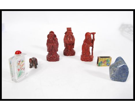 A collection of Oriental wares to include a set of three red Cinnabar lacquer type elder figurines, a tigers eye elephant fig