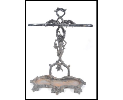 A late 19th / early 20th Century cast iron stick stand having an ebonised painted finish. The stand decorated with grape and 