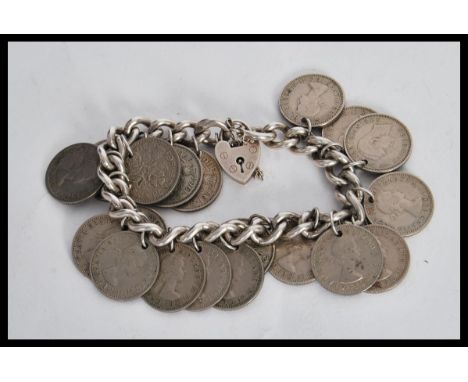 A sixpence coin bracelet on a curb link chain with a heart lock. Lock stamped silver. Gross weight 85.5g.