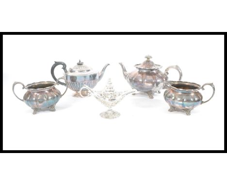 A group of silver plate to include a three piece tea service, additional teapot and silver plated oil lamp. Largest measures 