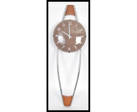 A retro 20th Century teak wood and chrome wall clock of unusual form, arabic chapter ring under convex glass set to a chrome 