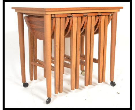 A vintage retro 20th century teak wood side table with four folding occasional / nest of four folding tables to the underside