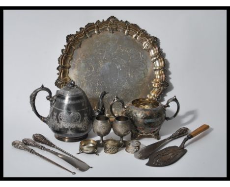 A collection of silverplate items to include a teapot having engraved foliate decoration and acorn finial lid with greek key 