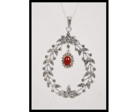 A stamped 925 silver necklace having a floral garland pendant set with marcasites and a coral cabochon drop. Weight 15.9g. Ch