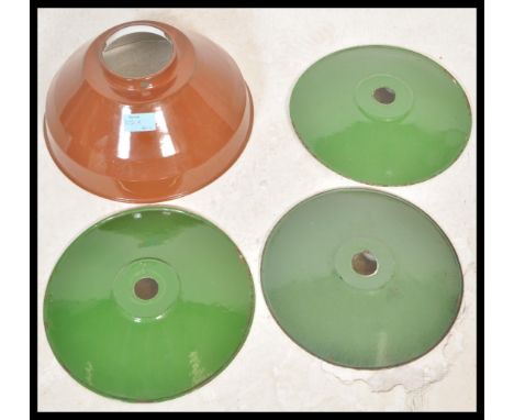 A group of four vintage retro 20th Century factory industrial pendant shades consisting of a brown enamel example and a set o