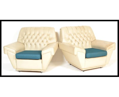A pair of vintage retro 20th Century arm chairs armchairs of Chesterfield type having button backs upholstered in white with 