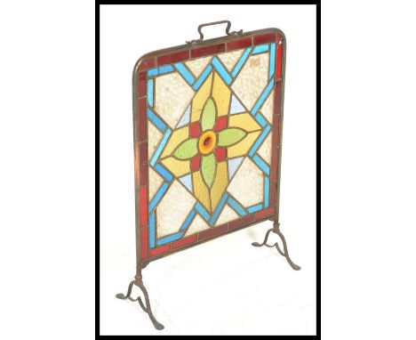 A 19th Century Victorian stained lead glass and brass surround fire screen, the centre designed as a flower, carry handle ato