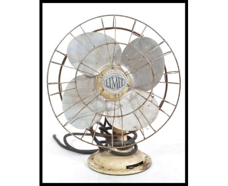 A vintage retro 20th Century industrial desk top table fan by Limit raised on a circular base the steel blades inside wire ca